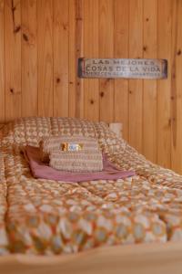 圣马丁德洛斯Nómada的一张带毯子和墙上标志的床