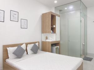胡志明市Hello SaiGon Homestay的一间卧室设有一张床和一个玻璃淋浴间
