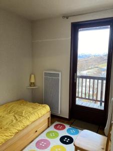 莱索尔Appartement de 2 chambres avec balcon amenage a Les Orres a 2 km des pistes的一间卧室设有一张床和一个大窗户
