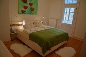 HeyerodeLandgasthof Alter Bahnhof的一间卧室配有一张带绿色床单的床和一扇窗户。