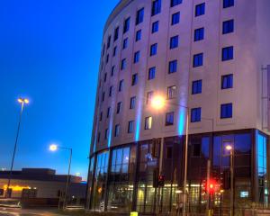 沃特福德Leonardo Hotel London Watford的建筑的侧面有蓝色的灯光