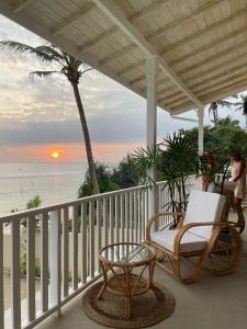 阿杭格默Lihinya Beach Villa Ahangama的海滩上带椅子和桌子的门廊