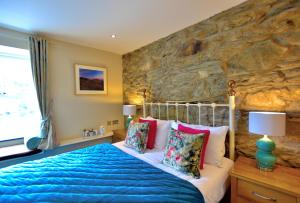 凯珀尔克里格Bryn Tyrch Rooms的一间卧室设有一张床和石墙