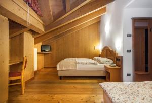 圣卡特琳娜瓦尔夫潘德兰奇尼酒店的一间卧室设有两张床,墙上配有电视。
