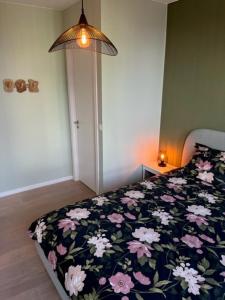 安特卫普"VH apartment" - center of Antwerp - free parking的一间卧室配有一张带花卉棉被的床