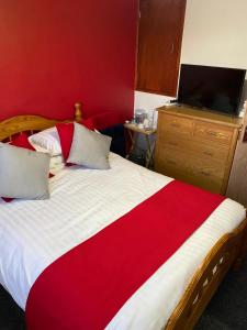 普里茅斯Southway Double Room near Derriford的一间卧室设有一张红色墙壁的大床