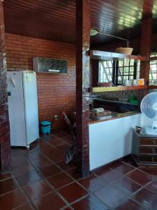 布希奥斯Flats Tartaruga Búzios的厨房配有白色冰箱和砖墙