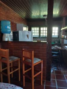布希奥斯Flats Tartaruga Búzios的厨房配有两把椅子和带冰箱的台面