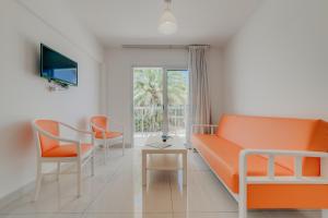 阿依纳帕Christos Napa Apartments的客厅配有橙色沙发和椅子