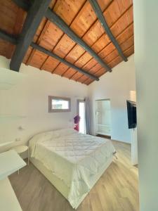 卡斯蒂亚达斯Domu Virginia的一间卧室设有一张大床和木制天花板。