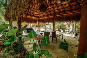 巴卡拉尔Totem Buenavista的一间带桌椅和稻草伞的餐厅