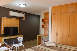 齐克拉约莫基克斯酒店的一间卧室配有一张床、一张书桌和一台电视。