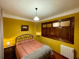 布维翁天使之家乡村民宿的一间卧室设有一张床和黄色的墙壁