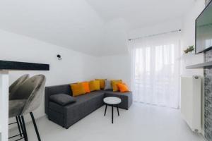 克拉古耶瓦茨Duga apartmani的客厅配有带橙色枕头的灰色沙发