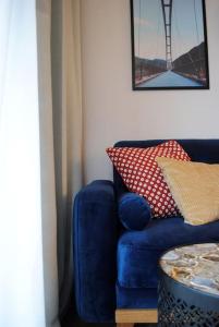 弗罗茨瓦夫Art Marina nad rzeką z bezpłatnym parkingiem的客房内的蓝色沙发、枕头和桌子