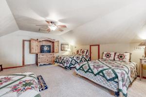 罗杰斯War Eagle - Lake House的一间卧室配有两张床和吊扇