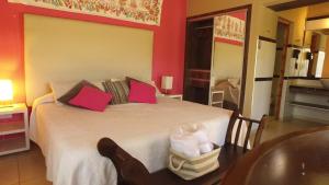 米娜克拉韦罗洛杉安卡雷斯度假村的一间卧室设有一张带红色墙壁的大床