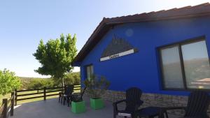 米娜克拉韦罗洛杉安卡雷斯度假村的蓝色的建筑,有椅子和标志