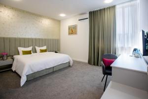 埃里温Benefice Hotel Yerevan的配有一张床和一张书桌的酒店客房