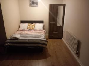 ThamesmeadLovely Shared 3 Bed Home Near The Thames的一间小卧室,配有一张带镜子的床