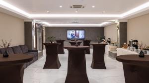 利沃夫达尼斯特尔尊贵酒店的一个带桌子和电视的大堂的沙龙