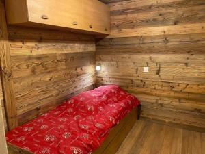 拉克吕萨Appartement La Clusaz, 3 pièces, 6 personnes - FR-1-459-28的角落处的一间小小屋,配有一张红色的床