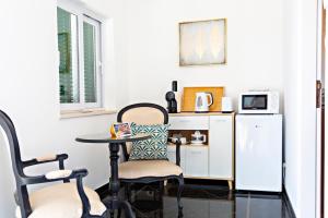 塔维拉Suite Bela Vista的客房设有桌子、两把椅子和冰箱。