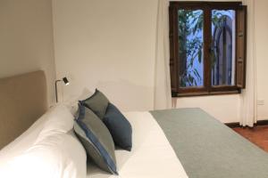 萨尔塔总督酒店的卧室配有带枕头的白色床和窗户。