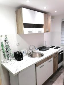 索科矿泉村Apartman Mata的白色的厨房设有水槽和炉灶。