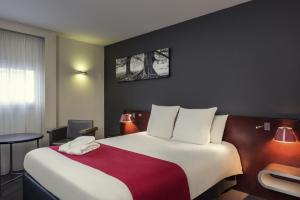 雷恩雷恩中央车站美居酒店的酒店客房设有一张带红色毯子的大床