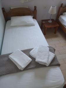 梅塔诺佛希斯Apartments Giannis的一间卧室配有两张床和白色毛巾。