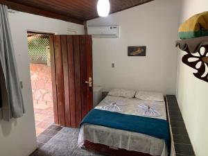 伦索伊斯Pousada e Camping Lumiar的一间小卧室,配有一张床和一扇门
