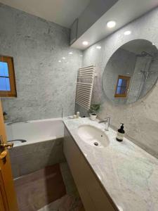 威拉尔-苏-罗伦Apartment with stunning view! Ski-in, ski-out的一间带水槽、浴缸和镜子的浴室