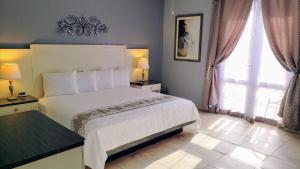 卡沃罗霍Combate Beach Resort的卧室配有白色的床和2扇窗户。
