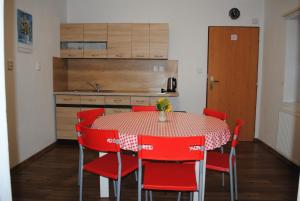 伊赫拉瓦Apartmán Štěpánka的厨房配有桌子和红色椅子