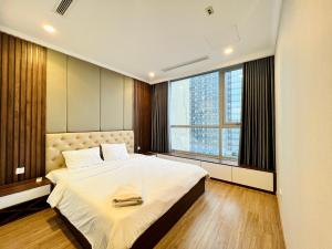胡志明市The Landmark Vinhomes-Service Apartment的一间卧室设有一张大床和一个大窗户