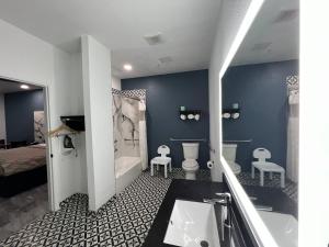 休斯顿Grand Villa Inn Galleria的一间带水槽、浴缸和卫生间的浴室