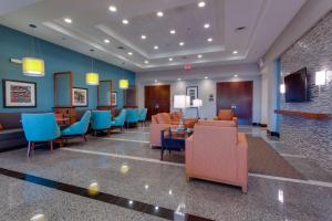 盖恩斯维尔Drury Inn & Suites Gainesville的大堂设有蓝色和橙色椅子的等候室