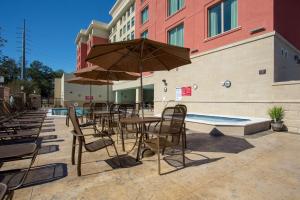 盖恩斯维尔Drury Inn & Suites Gainesville的一个带桌椅的庭院和一个游泳池