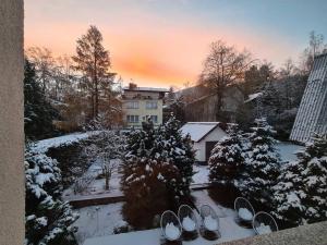 卡尔帕奇Rezydencja Green Hill - ekskluzywny dom w Karpaczu的一座带雪盖的花园,其背后是一座建筑