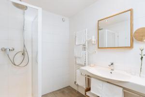 因斯布鲁克Hotel Kögele mit Restaurant bei Innsbruck Axamer Lizum的白色的浴室设有水槽和镜子