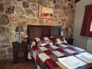 里奥帕尔Casas Rurales Majana的一间卧室设有一张床和石墙