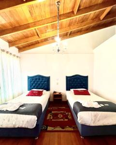 库斯科Hotel Feimar的配有木天花板的客房设有两张床。