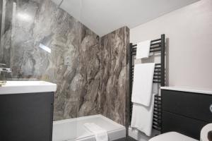 伊尔明斯特The Five Dials Inn的浴室设有石墙、卫生间和水槽
