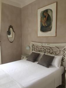 乌尔比诺B&B Aquilone的卧室配有一张白色床,墙上挂有绘画作品