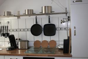 伍珀塔尔Ferienwohnung Hardtblick的厨房配有挂在墙上的锅碗瓢盆