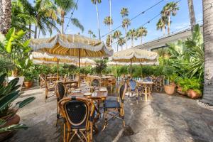 洛杉矶好莱坞罗斯福酒店的一间带桌椅和遮阳伞的餐厅