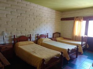 蒂尔卡拉Hotel El Jardin Dante的一间卧室设有两张床,另一面设有窗户。