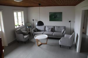 GunsjögårdenVilla Lägervik Vitsand的客厅配有沙发、两把椅子和一张桌子