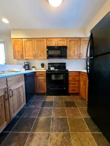 帕克城SNOW FLOWER 150 condo的厨房配有黑色冰箱和木制橱柜。